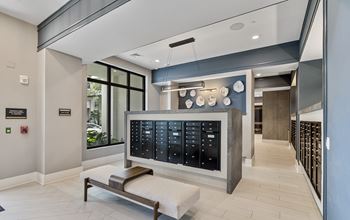 A modern waiting room with a bench and a large black board with many compartments at Mayla Pompano, Pompano Beach, FL